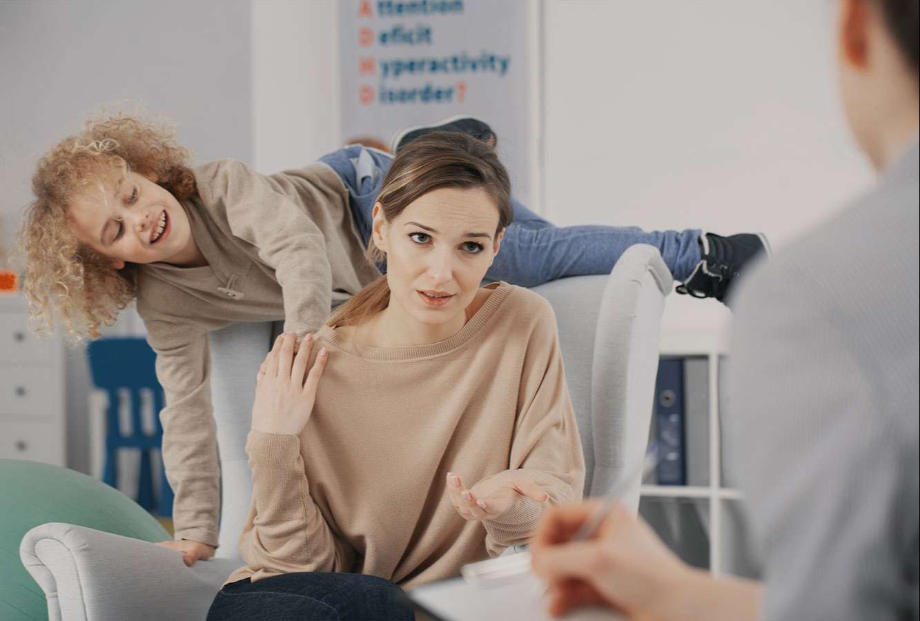 Kind tobt bei Beratungsgespräch zu ADHS mit der Mutter